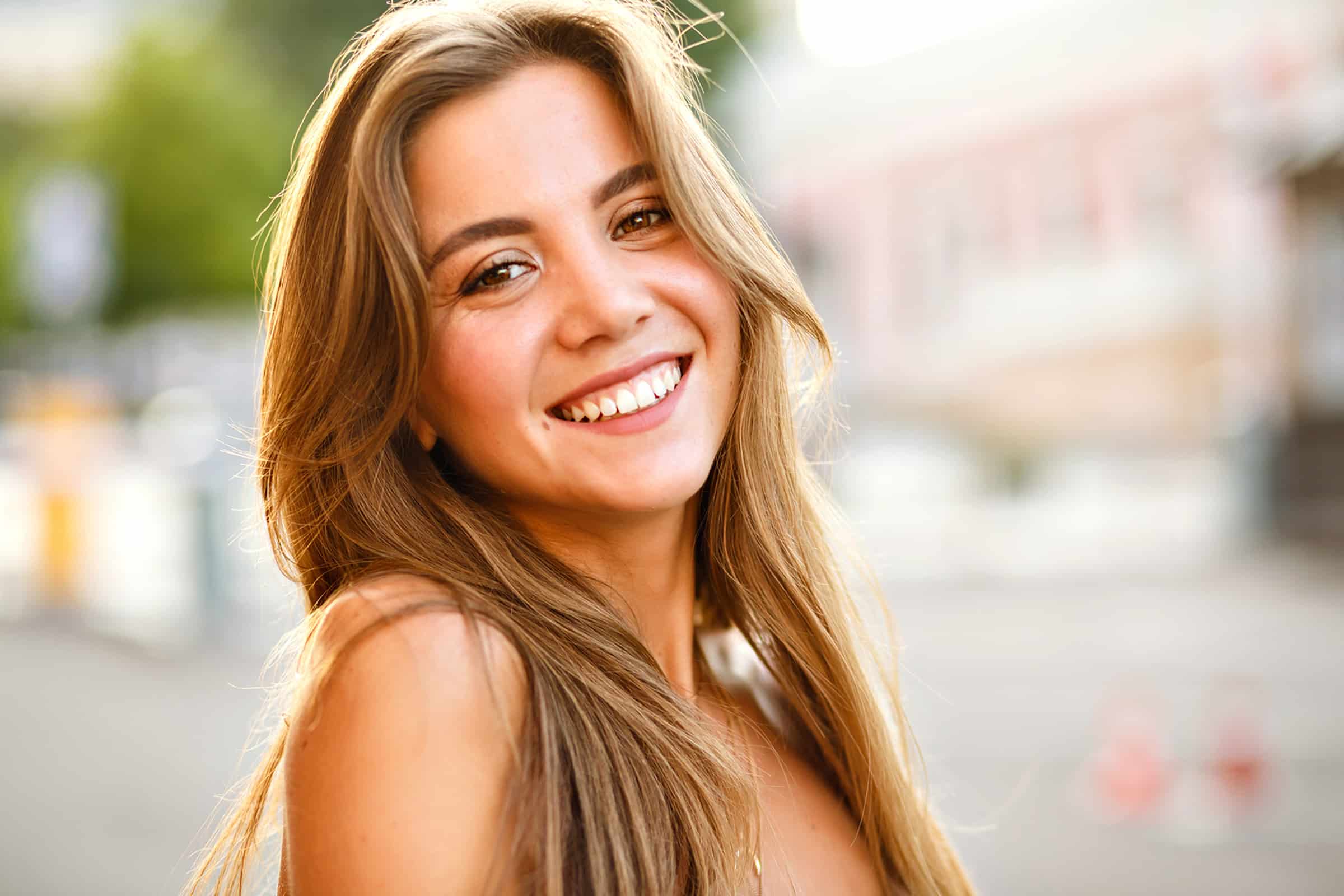 Woman smiling after getting a damaged tooth removed in Brentwood, TN