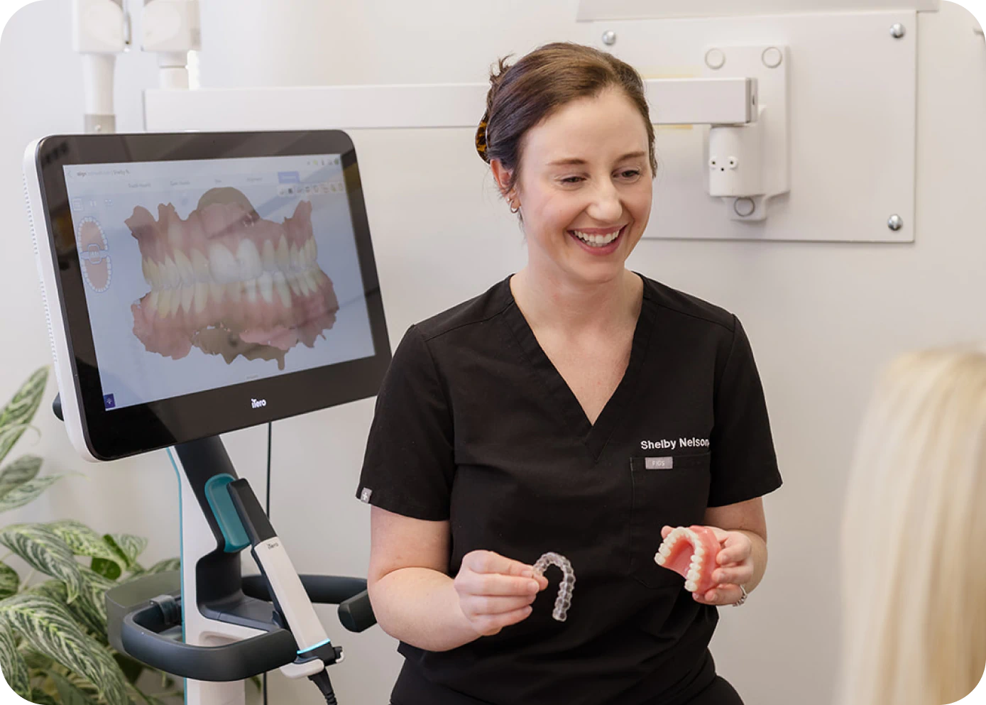 Woman looking at her teeth in a mirror in Brentwood TN